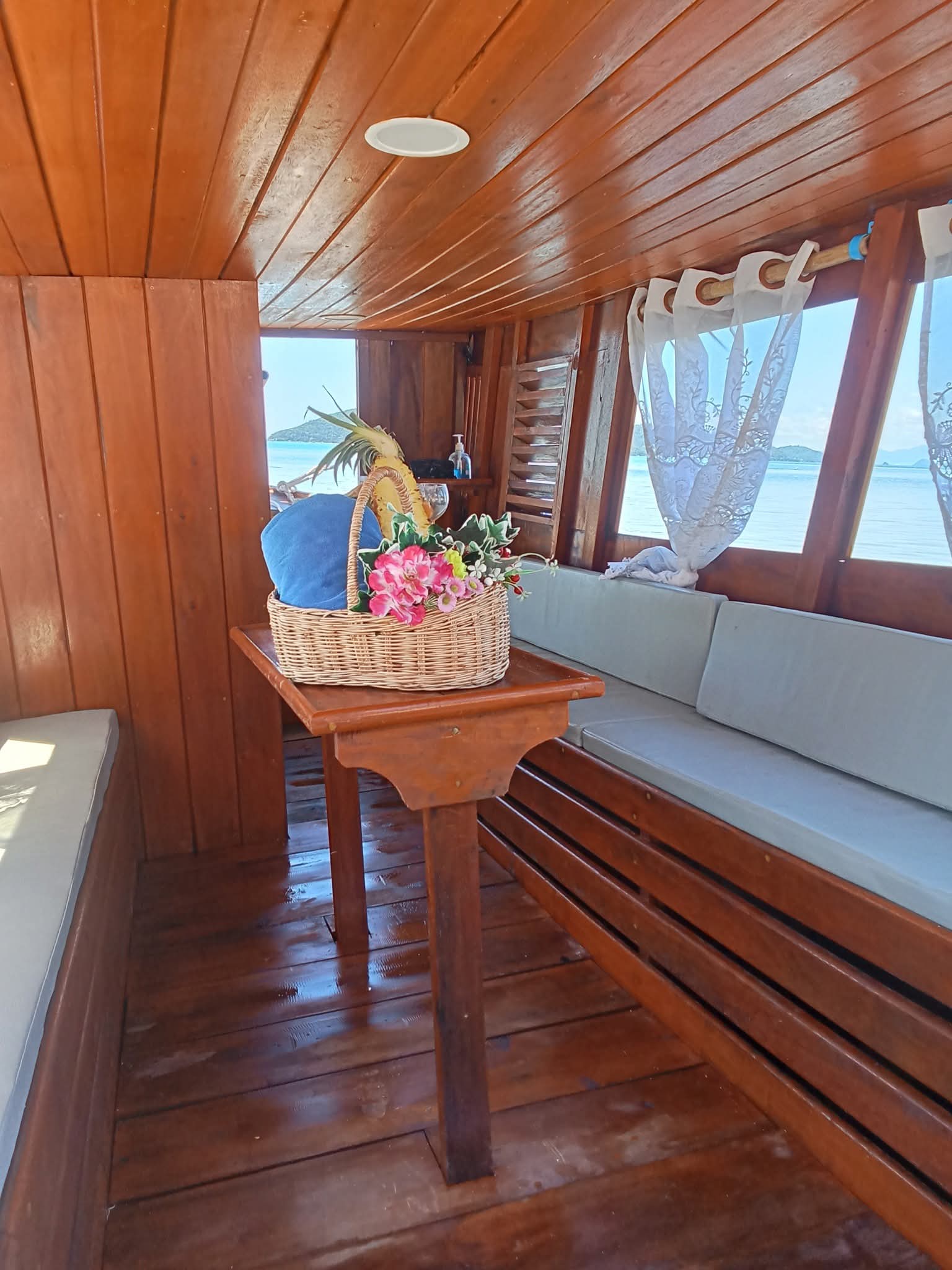 Comfortable cabin interior of the Dolphin Tour Samui boat with a welcome gift basket