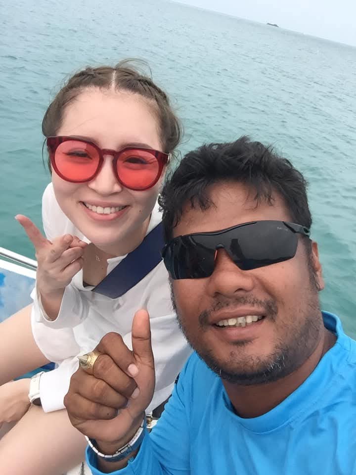 A happy guest with a Dolphin Tour Samui crew member onboard